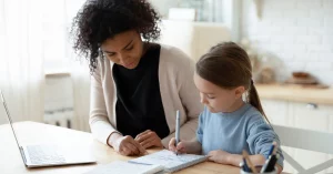 after school nanny helping child with homework