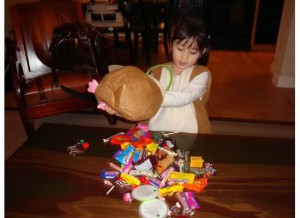 julia-Toddler dumping candy from Halloween on table