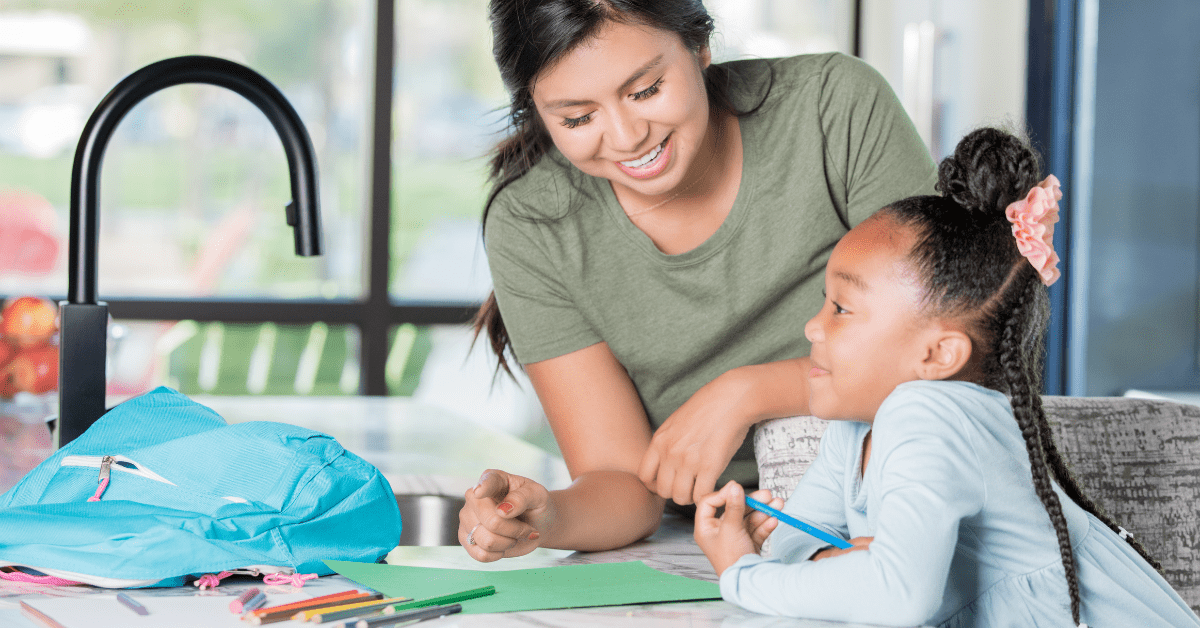 after school sitter helping child with homework at kitchen counter