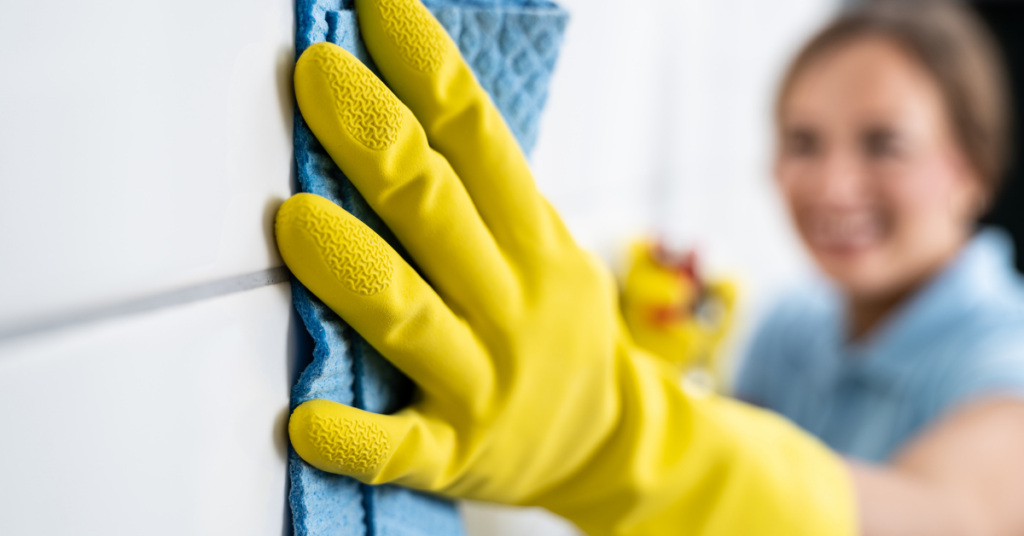 housekeeper cleaning bathroom tiles