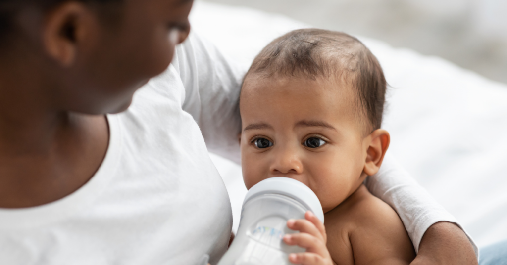 baby being fed a bottle by infant caregiver