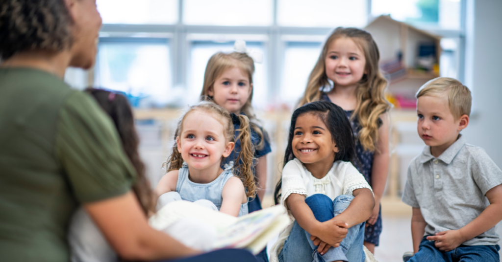 toddlers listening to teacher at child care center
