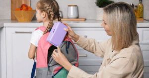 nanny packing child's lunch into backpack