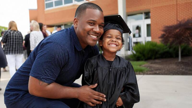dad taking photo at preschool or kindergarten graduation ceremony