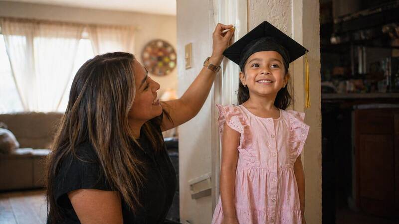 parent marking child height on doorframe as a graduation milestone